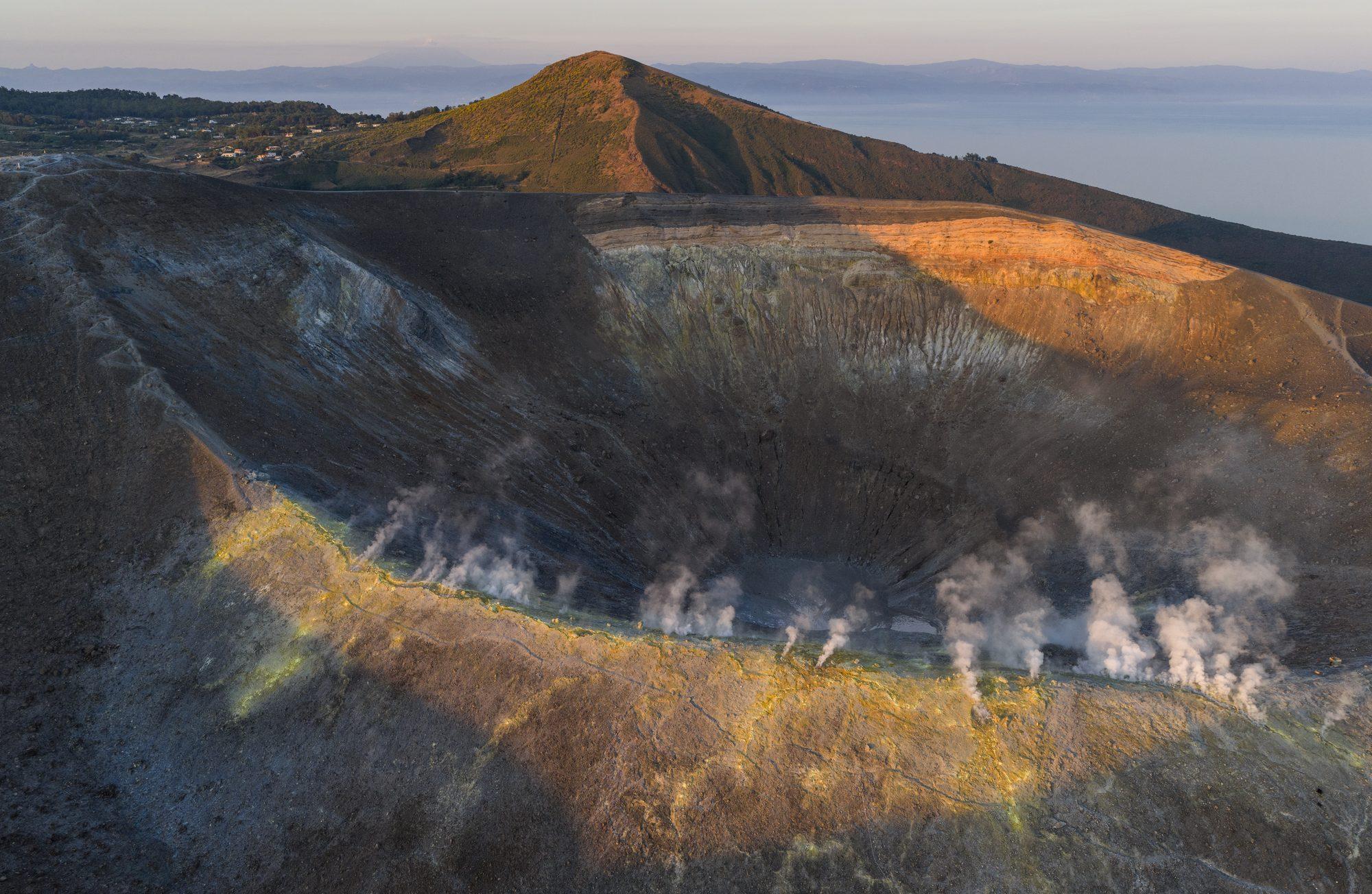 Golden light on a steaming volcanic crater seen from above