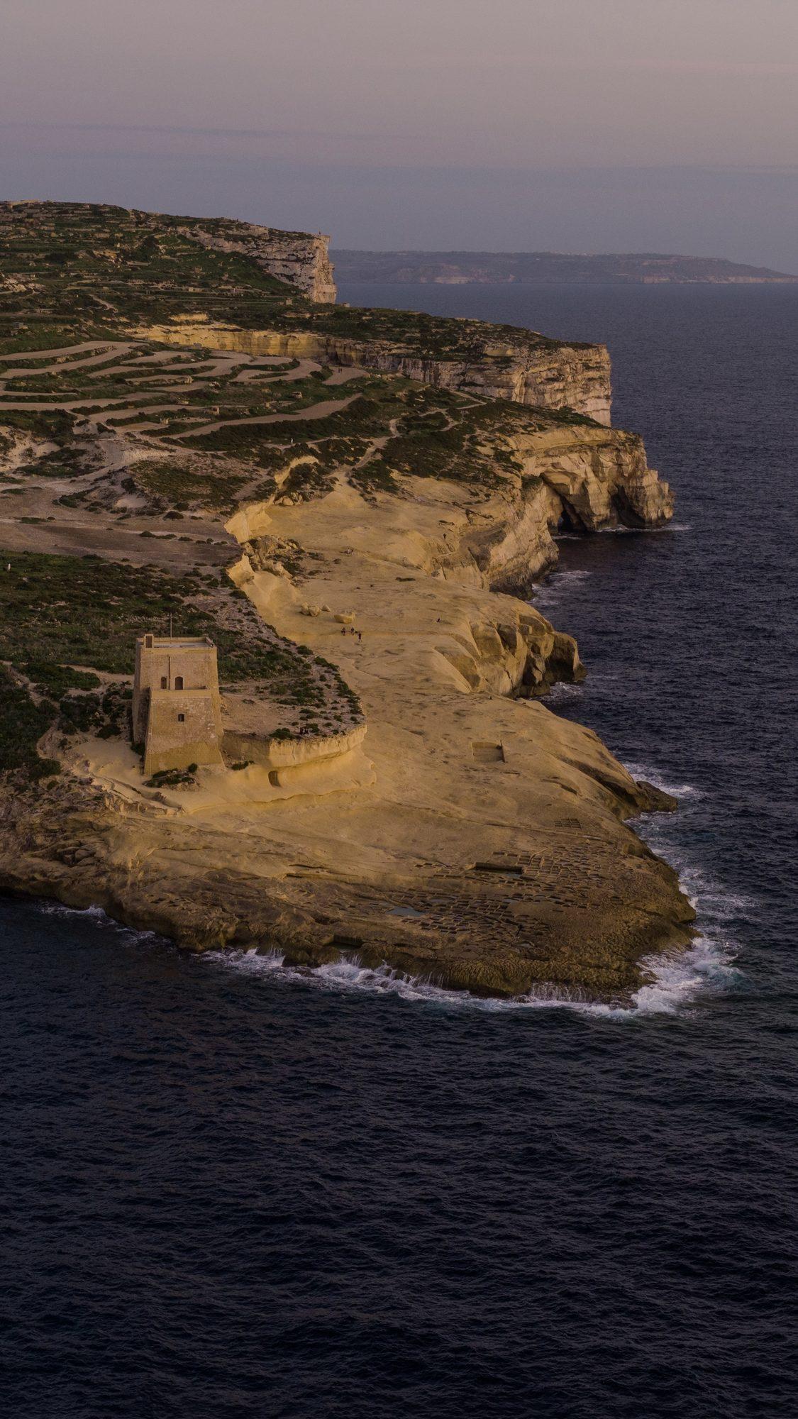 Aerial view of coastal cliffs at Xlendi, Gozo, at dusk