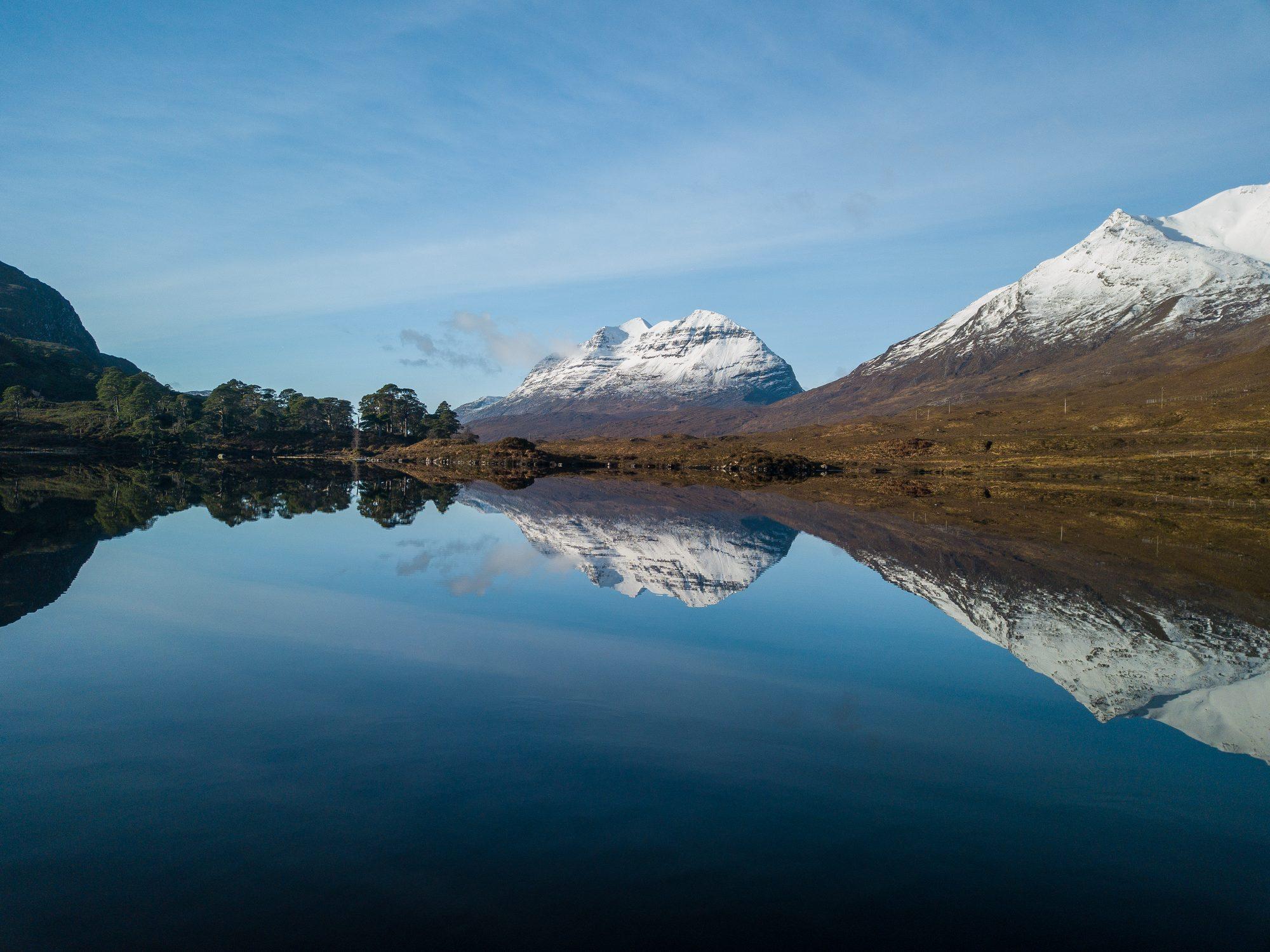Snow-capped mountains mirrored in a still lake