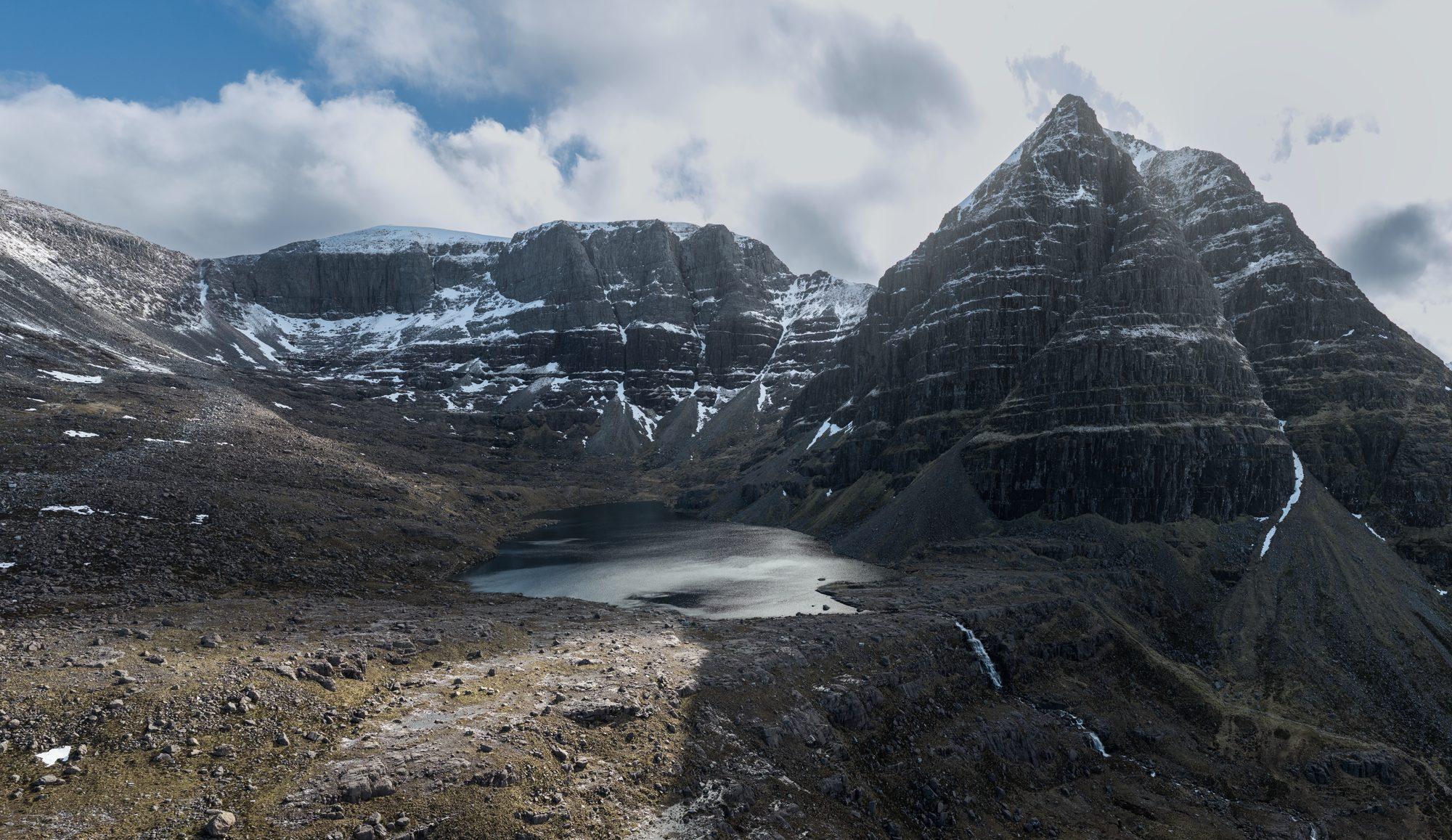A dramatic peak rising above a mountain tarn